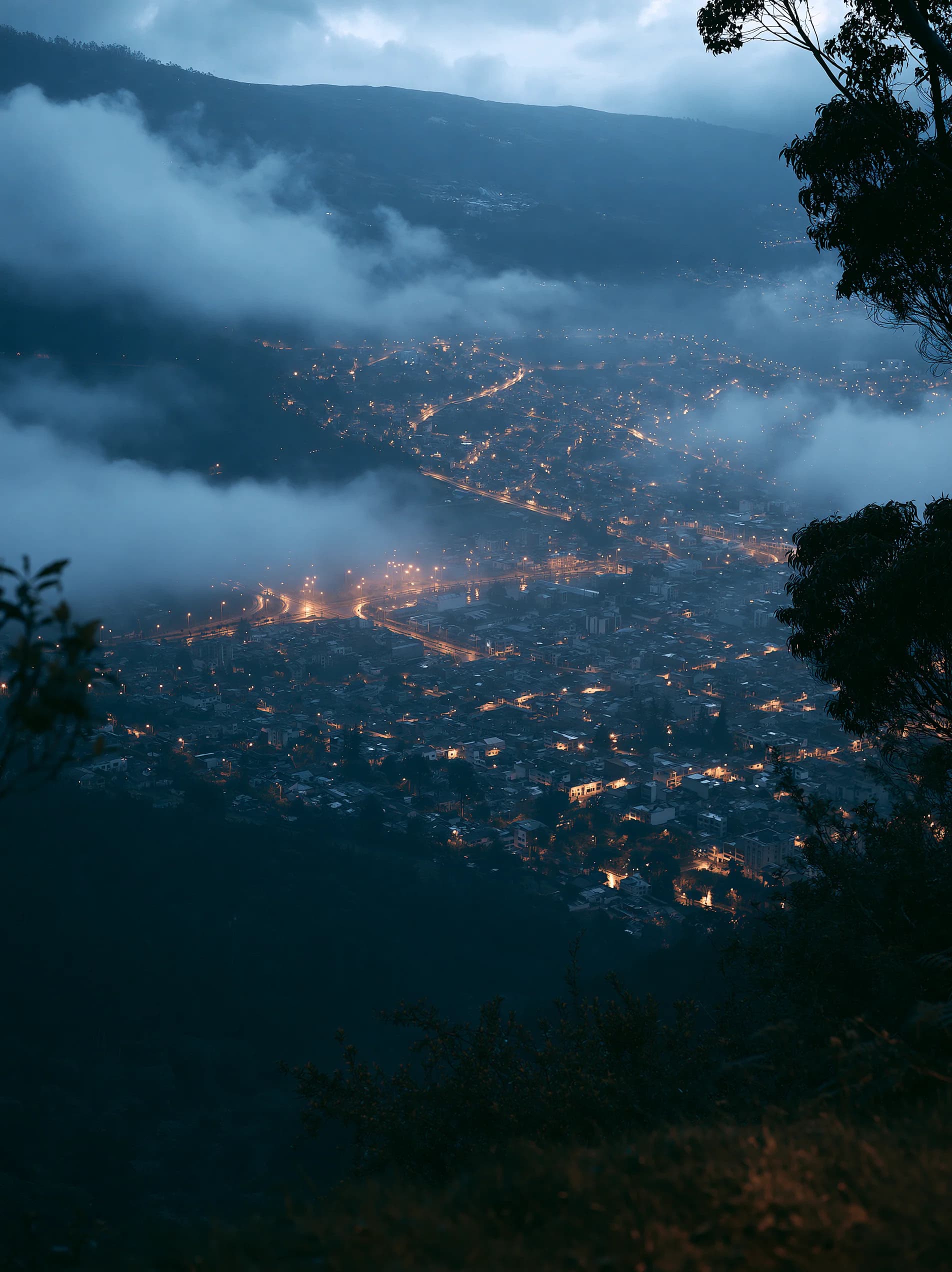 Ciudad colombiana entre montañas y niebla al anochecer